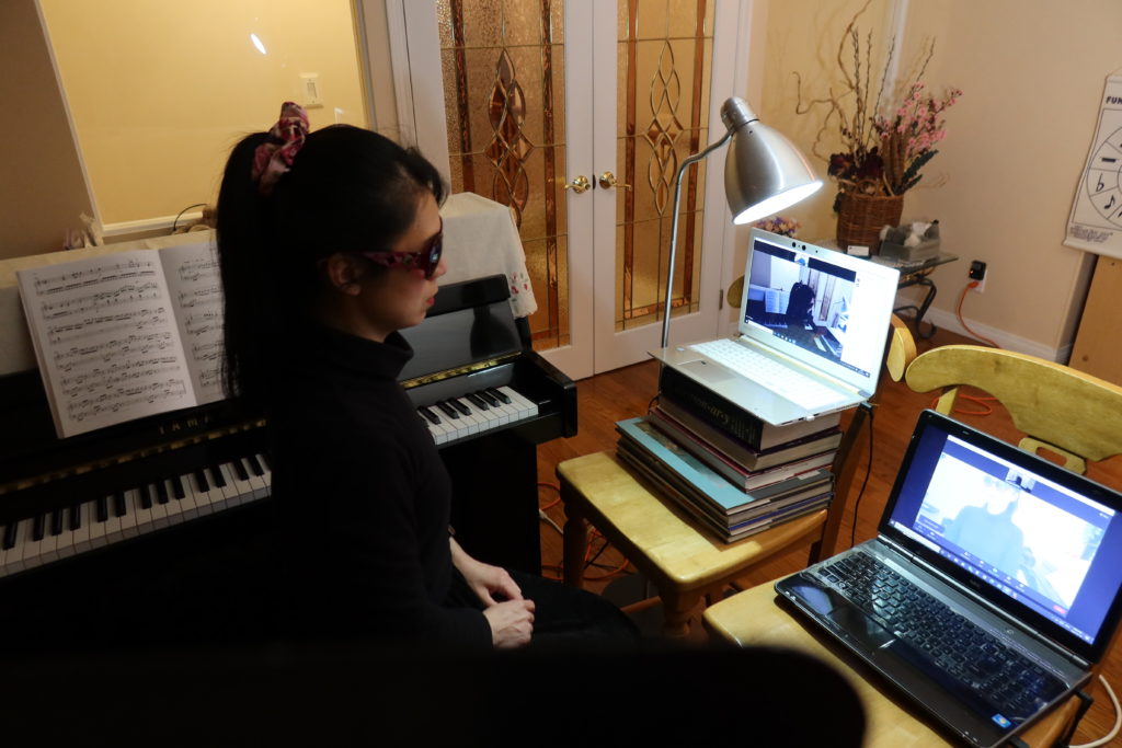 West Vancouver's piano teacher Yuki uses two laptops for online piano lessons.