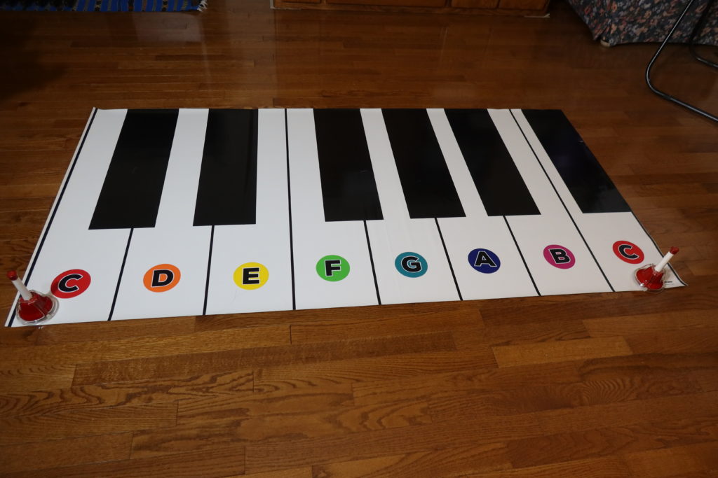 West Vancouver's piano teacher Yuki uses many music teaching aids - floor keyboard, music alphabet manipulatives and bells.